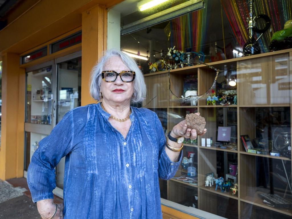 Dawn Sanders standing in front of her business of 30-years, Warehouse 73 Emporium, while holding the rock which smashed her shopfront window. Picture: Floss Adams.