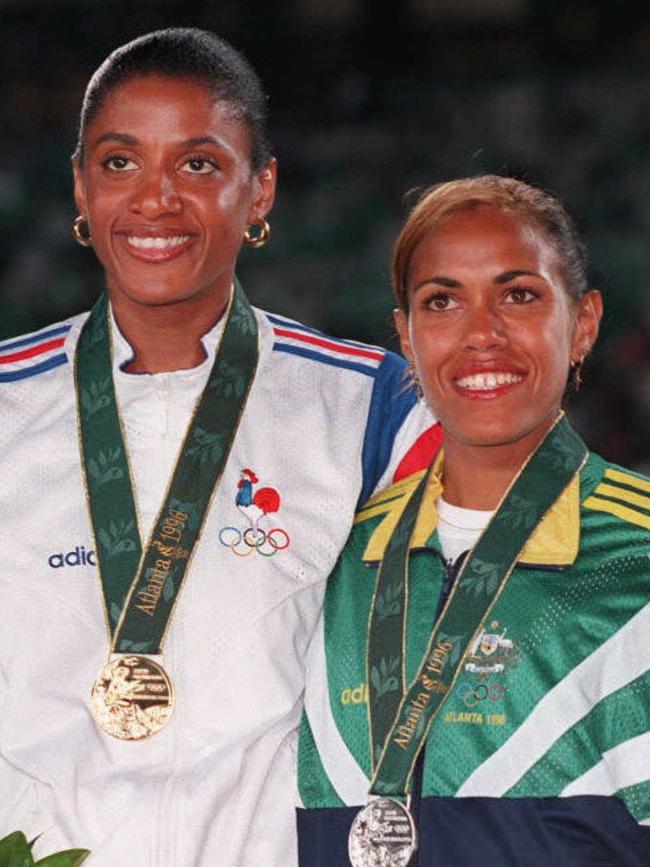 Perec on the podium with Cathy Freeman after winning gold at the 1996 Atlanta Olympic Games. \