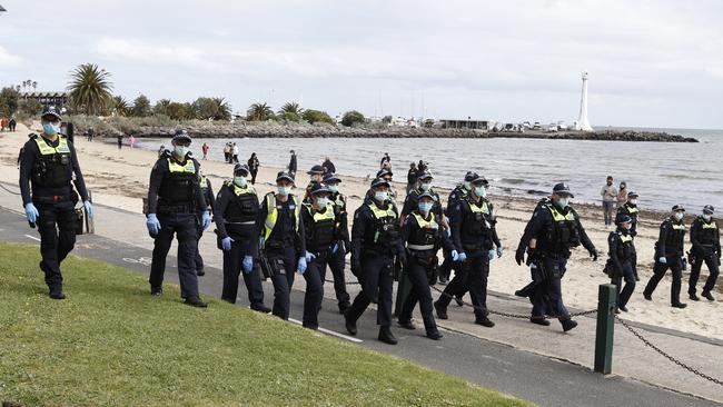 Police march along the beach at St Kilda. Picture: Alex Coppel