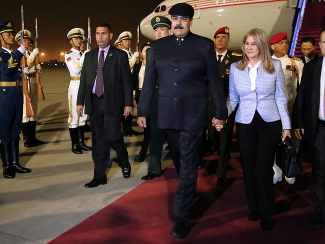 This handout picture released by the Venezuelan Presidency shows Venezuelan President Nicolas Maduro (C) and his wife Cilia Flores (2-R), disembarking from their plane in Beijing, on September 13, 2018. - Maduro arrived in China to strike deals with his crisis-hit country's biggest creditor. Before departing Caracas, Maduro said the trip was "very necessary, very opportune and full of great expectations." (Photo by Francisco BATISTA / Venezuelan Presidency / AFP) / RESTRICTED TO EDITORIAL USE - MANDATORY CREDIT "AFP PHOTO - Venezuelan Presidency / Francisco BATISTA" - NO MARKETING NO ADVERTISING CAMPAIGNS - DISTRIBUTED AS A SERVICE TO CLIENTS