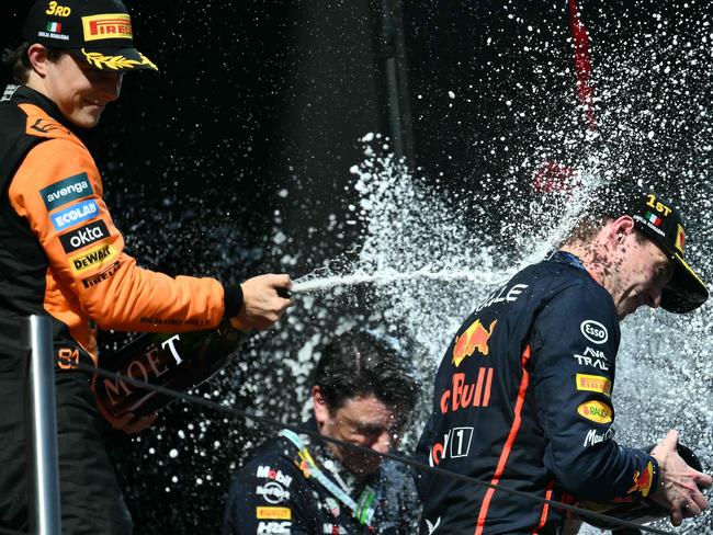 Third-placed McLaren's Australian driver Oscar Piastri (L) and winner Red Bull Racing's Dutch driver Max Verstappen celebrate on the podium after the 2025 Emilia Romagna Formula One Grand Prix at the Imola autodrome in Imola, on May 18, 2025. (Photo by Marco BERTORELLO / AFP)