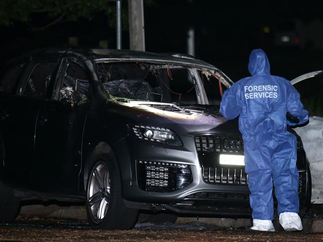 Police with burnt-out car linked to Barbaro’s murder. Picture: Bill Hearne