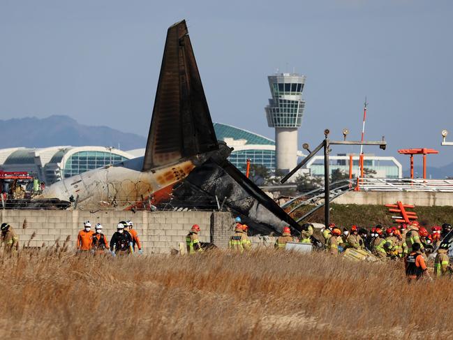 Rescue workers near the tail section of the Jeju Air Boeing 737-800 series aircraft. Picture: AFP