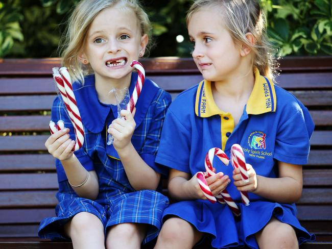 7-year-old Bronte Hawkins and 5-year-old Anika Hawkins, Teneriffe, enjoying candy canes which have been discouraged from many Queensland schools leading into Christmas. Pics Tara Croser.