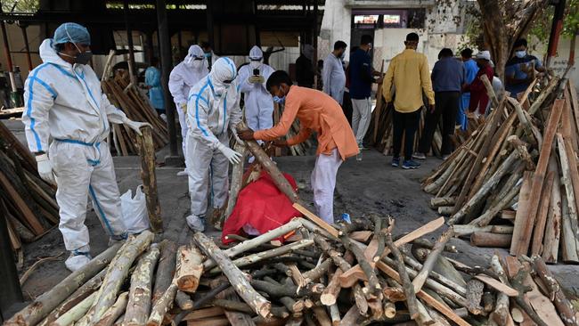 Family members and relatives wearing protective gear prepare to perform the last rites of a victim who died of Covid-19 at a crematorium in Ghazipur this month. Picture: AFP