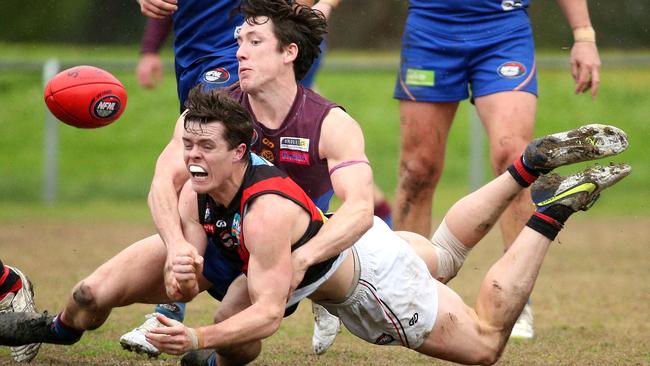 Eltham’s Daniel Horsfield gets a handball away under pressure from Riley Loton of Banyule. Picture: Hamish Blair