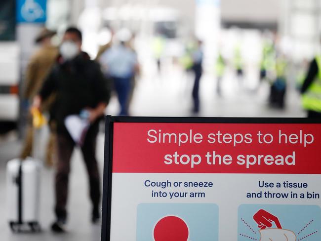 A returning overseas traveller walks towards waiting buses at Sydney Airport. Picture: Getty Images