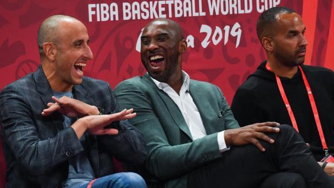 Basketball greats Kobe Bryant (centre) and Manu Ginobili (left) watch the match from courtside. Picture: AFP