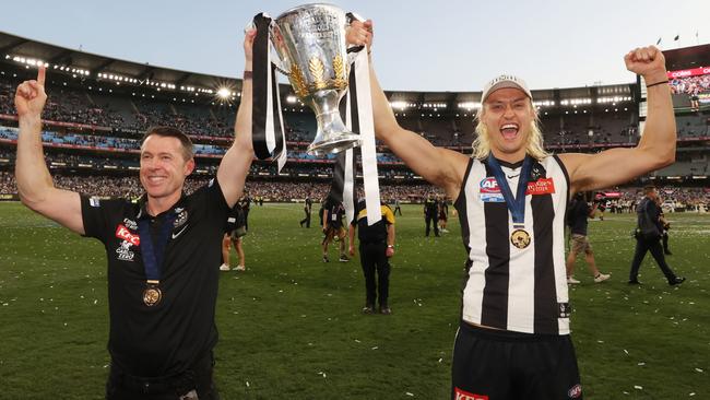 Pies coach Craig McRae and captain Darcy Moore celebrate with the premiership cup in 2023. Picture by David Caird