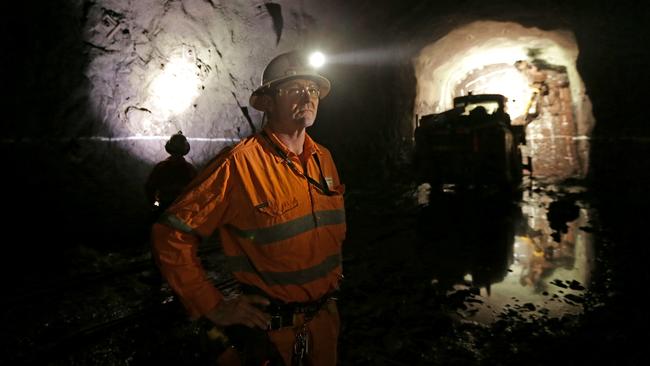 Dwayne Gum underground as a header works in the background to drill into ore deposits at BHP Billiton's Olympic Dam project in South Australia. The mine produces Copper, Gold, Silver & Uranium.