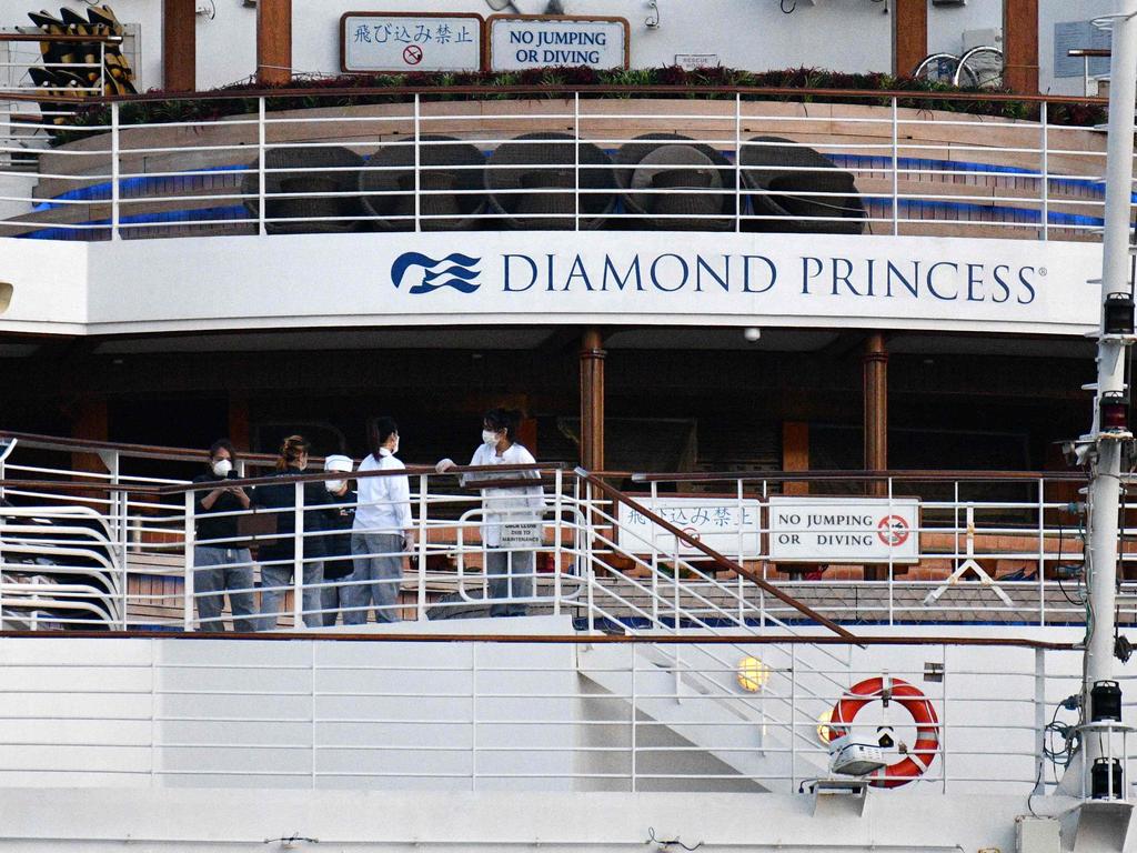 This picture taken on February 24, 2020 shows crew members aboard the Diamond Princess cruise ship at the Daikoku Pier Cruise Terminal in Yokohama port. - Hundreds of crew members aboard a coronavirus-riddled cruise ship in Japan began disembarking on February 27, the government said. (Photo by Kazuhiro NOGI / AFP)