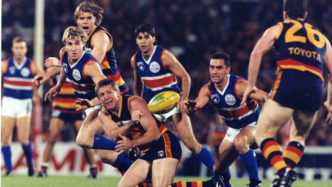 Chris McDermott handpasses to Mark Bickley as Tony Liberatore and Richard Osborne (l) close in, in 1995. Picture: Neon Martin