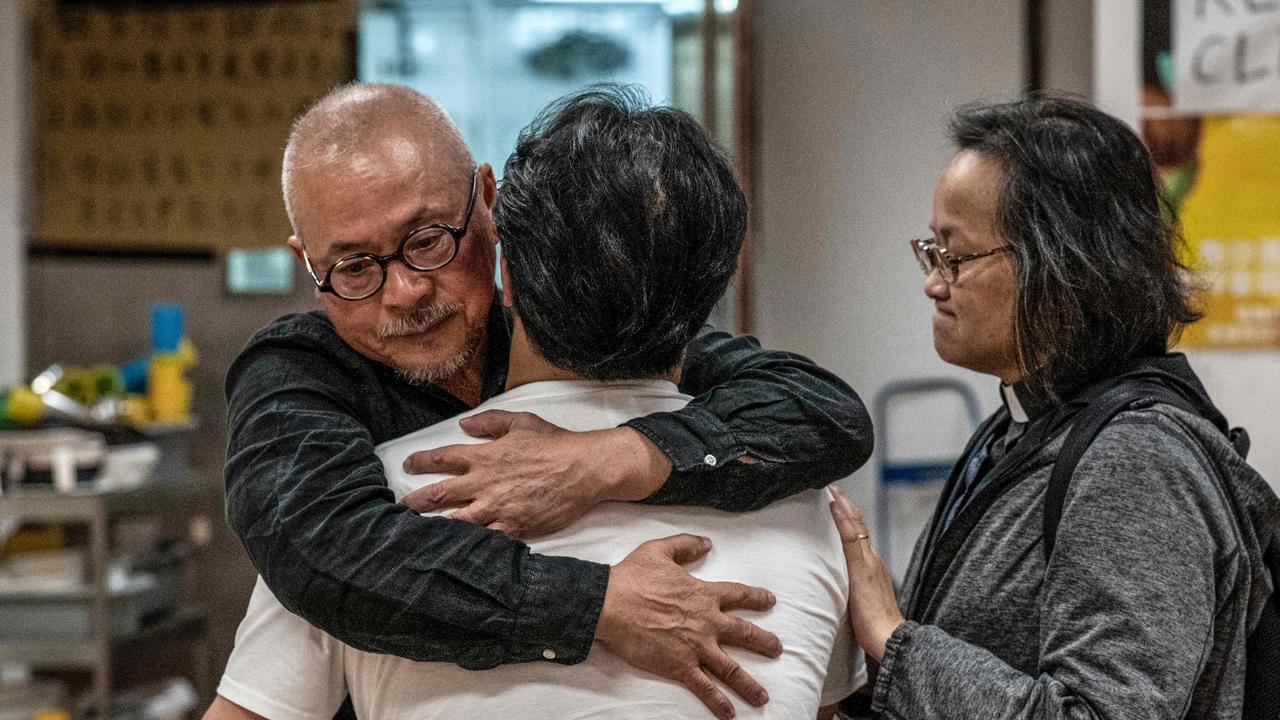 Two catholic priests hug and comfort a protester (C) in the campus of the Hong Kong Polytechnic University where dozens of pro-democracy protesters remain holed up, in the Hung Hom district of Hong Kong on November 24, 2019. Picture: Nicolas Asfouri / AFP