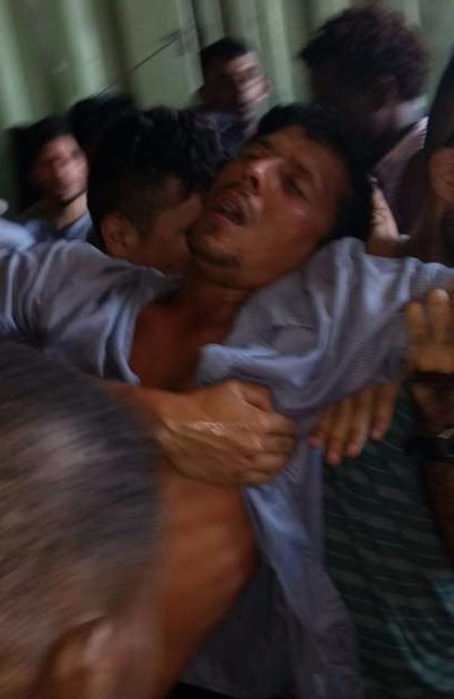 This supplied image shows an asylum seeker at Manus collapsing and being helped by fellow detainees. Picture: AAP Image/Supplied by Refugee
