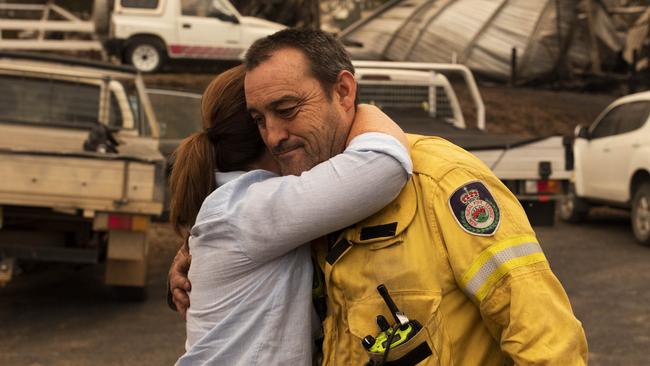 Mark Ayliffe at the Cobargo RFS station, NSW receives a hug from Jenny Morrison. Picture by Sean Davey.