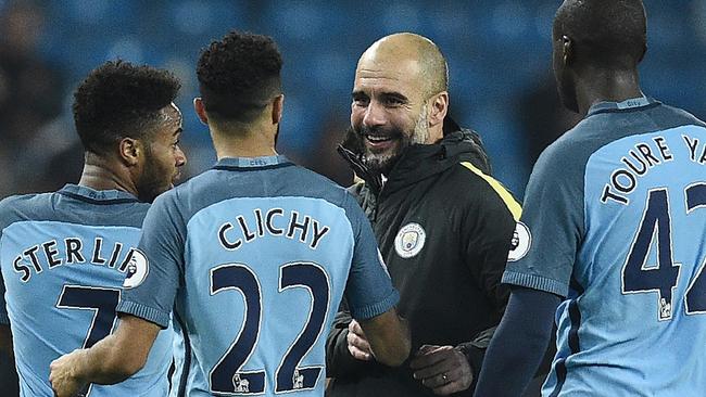 Manchester City's Spanish manager Pep Guardiola (C) congratulates his players.