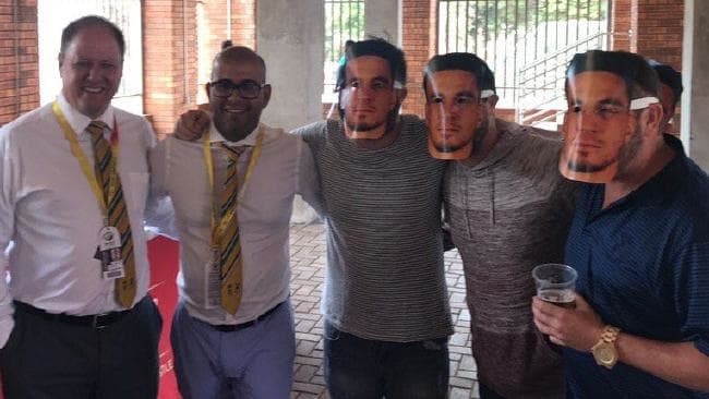 South African cricket officials Clive Eksteen (left) and Altaaf Kazi (second from left) pose with fans wearing Sonny Bill Williams masks, a slur against David Warner’s wife Candice.