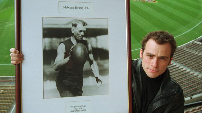 Mark Warne-Smith with a picture of his grandfather, Brownlow Medallist Ivor Warne-Smith.