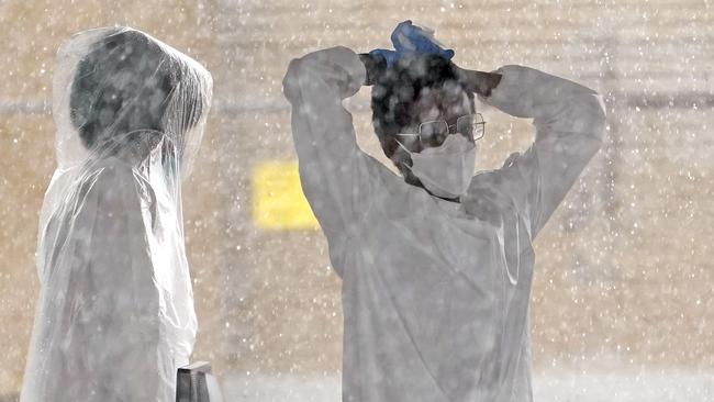 Healthcare workers take cover from the rain at a COVID-19 testing site in Houston on Thursday (AEST). Picture: AP