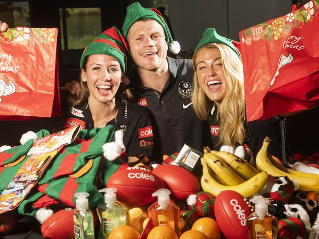 Collingwood stars Kelsey Browne, Taylor Adams and Sarah Rowe put their skills and formidable hand/eye co-ordination to good use wrapping presents and packing more than 500 hampers with goodies and gifts donated by Coles. Picture: Rob Leeson