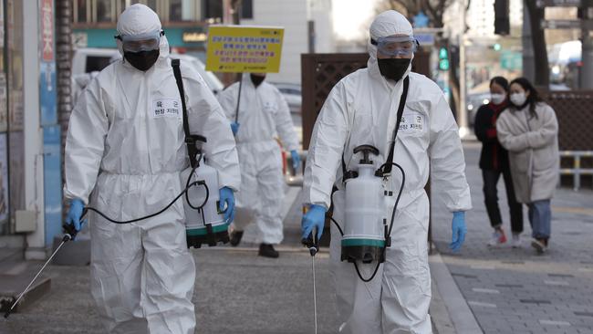 South Korean soldiers wearing protective gear spray disinfectant as a precaution against the new coronavirus on a street in Seoul, South Korea. Picture: AP