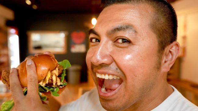 Henry tucks into the Mare Burger at his newly opened Mt Druitt restaurant. 