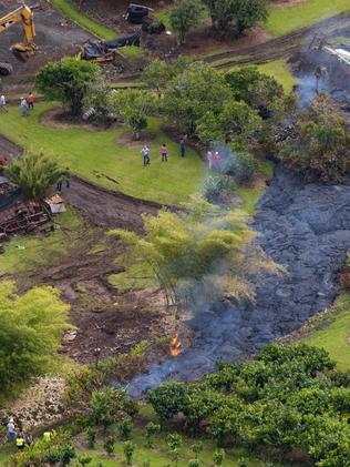 Locals watch as it comes close to homes. Picture: Bruce Omori/Paradise Helicopters.