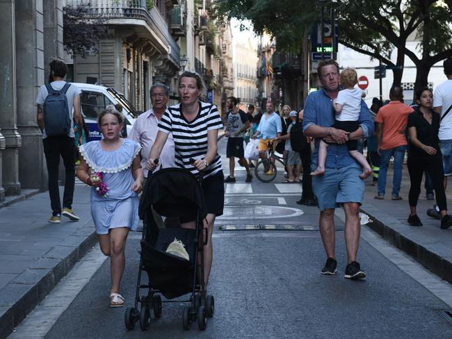 People flee the scene in Barcelona, Spain, after a white van jumped the sidewalk in the historic Las Ramblas district, crashing into a summer crowd. Picture: AP