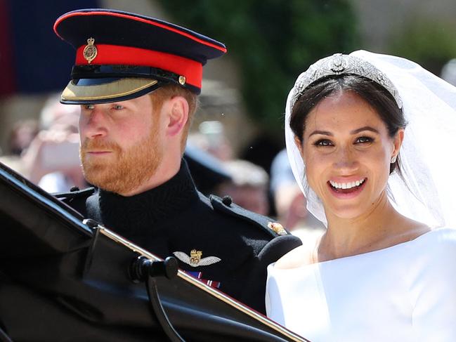 (FILES) In this file photo taken on May 19, 2018 Britain's Prince Harry, Duke of Sussex and his wife Meghan, Duchess of Sussex begin their carriage procession in the Ascot Landau Carriage after their wedding ceremony in Windsor. - Queen Elizabeth II is saddened by the challenges faced by her grandson Prince Harry and his wife Meghan, and takes their allegations of racism in the royal family seriously, Buckingham Palace said on March 9, 2021. "The whole family is saddened to learn the full extent of how challenging the last few years have been for Harry and Meghan. The issues raised, particularly that of race, are concerning," the palace said in a statement released on the queen's behalf. (Photo by Gareth Fuller / POOL / AFP)