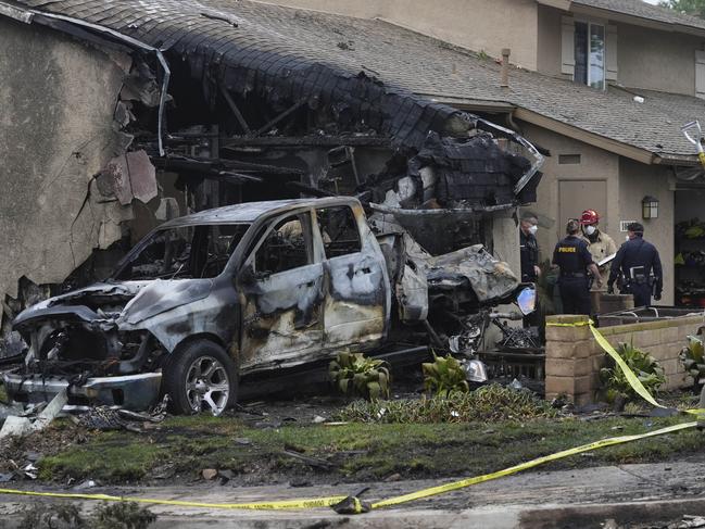 Authorities work the scene where a small plane crashed into a San Diego neighborhood, setting several homes on fire and forcing evacuations along several blocks early Thursday, May 22, 2025. Picture: AP Photo/Gregory Bull.