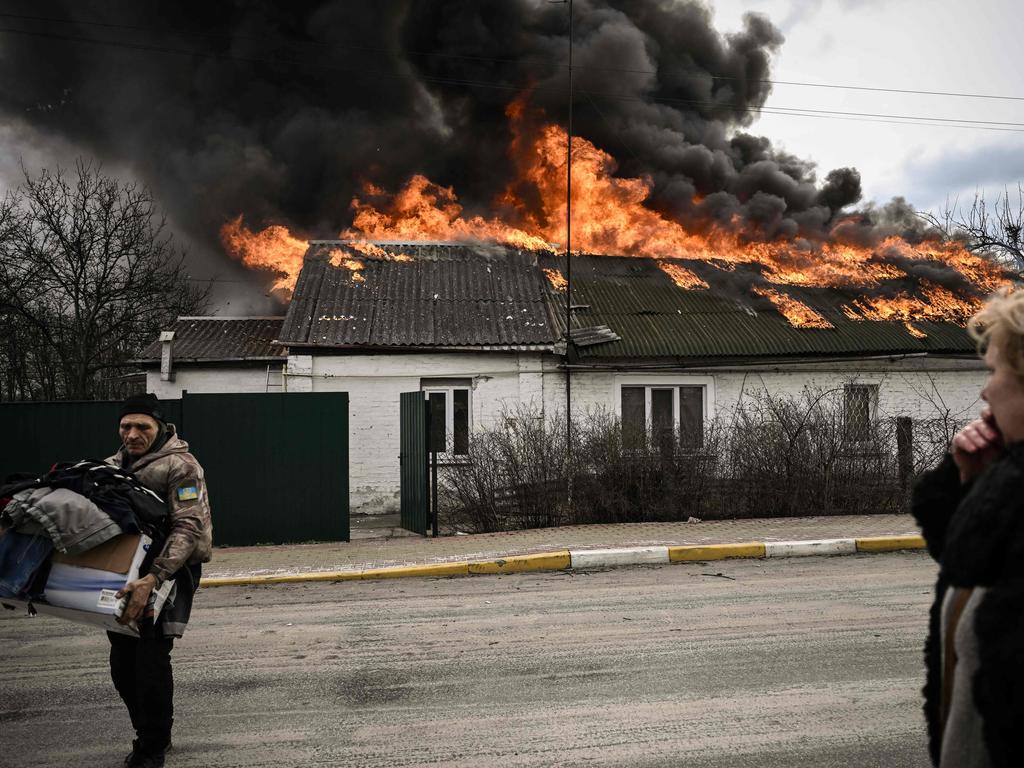 A man removes personal belongings from a burning house after being shelled in the city of Irpin, outside Kyiv, on March 4, 2022. Picture: Aris Messinis / AFP)