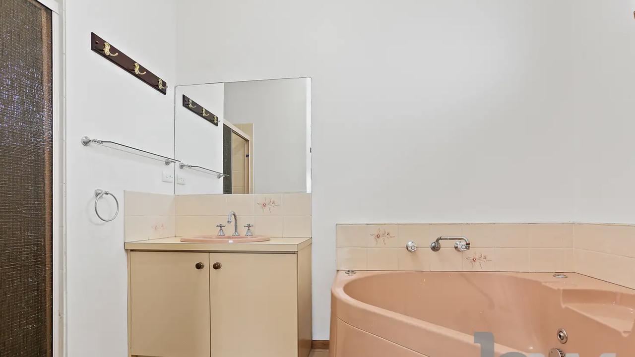 Bathroom: Before a dated 1980s style bathroom with a pink bath