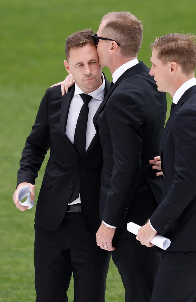 Joel Selwood, Adam Selwood and Scott Selwood embrace during Troy Selwood's funeral Service.