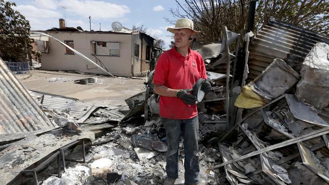 Steve Emery goes through the ruins of his wife's antique business which was destroyed along with his home at Magdalla in the Pinery fire on Wednesday. Photo by Kelly Barnes/The Australian.