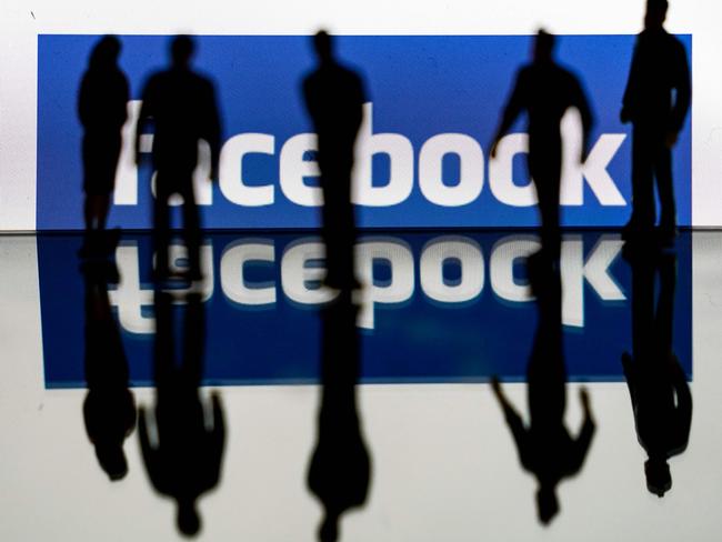 (FILES) In this file photo taken on February 14, 2020 silhouettes are seen in front of the logo of US social media Facebook in Brussels. - Facebook on September 1, 2020 said that it has caught a budding Russia-linked campaign to fuel political chaos in the US, working off a tip from the FBI in its latest take-down of coordinated inauthentic behavior at the leading social network. The small network of 13 Facebook accounts and two pages posing as journalists and targeting left-wing progressives was removed for violating a policy against "foreign interference" at the platform. (Photo by Kenzo TRIBOUILLARD / AFP)