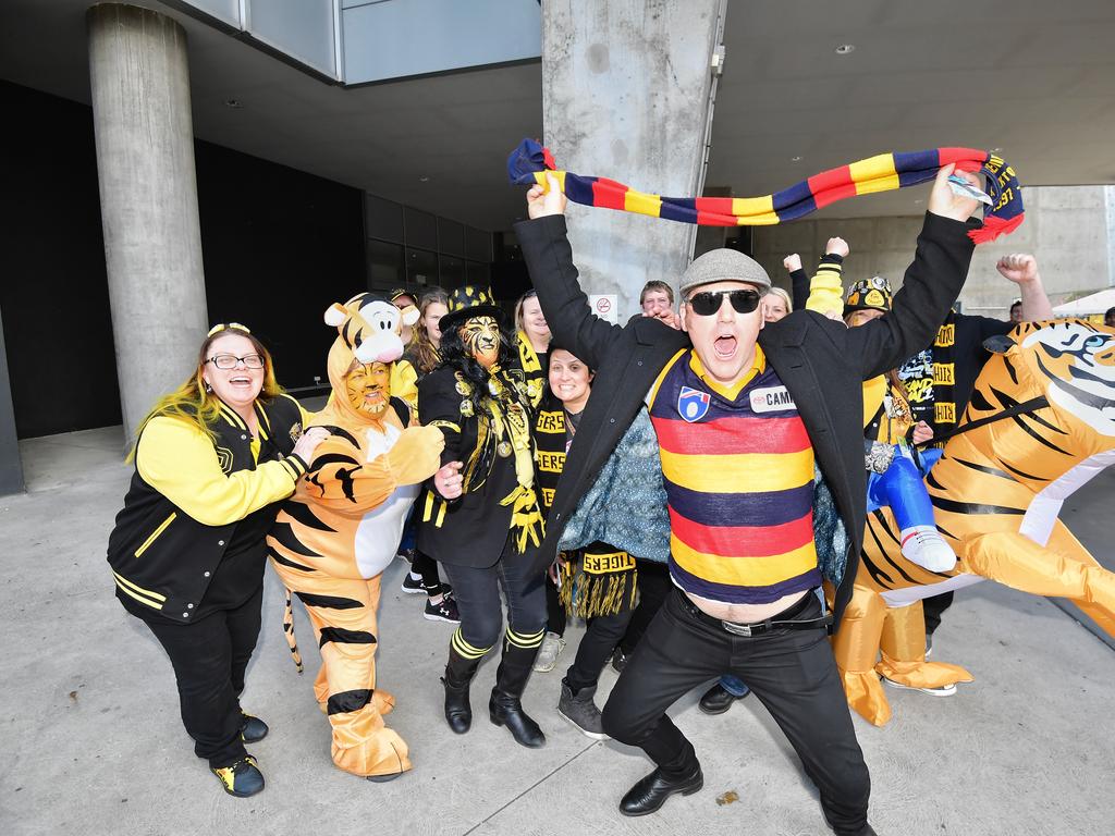 A Crows fan crashes a Tigers supporters’ photo as fans stream into MCG. Picture: Jason Edwards