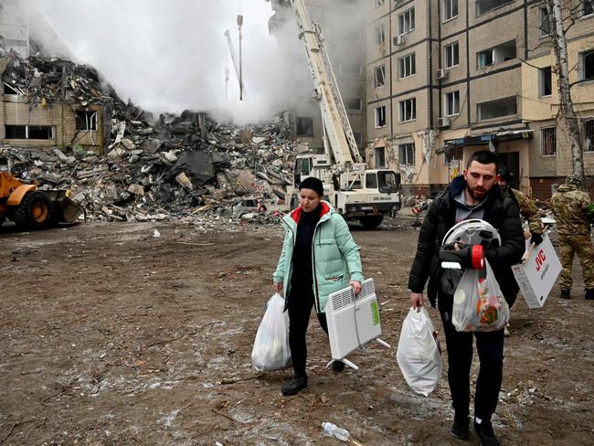 Residents carry their belongings from a residential building destroyed after a missile strike, in Dnipro. Picture: AFP