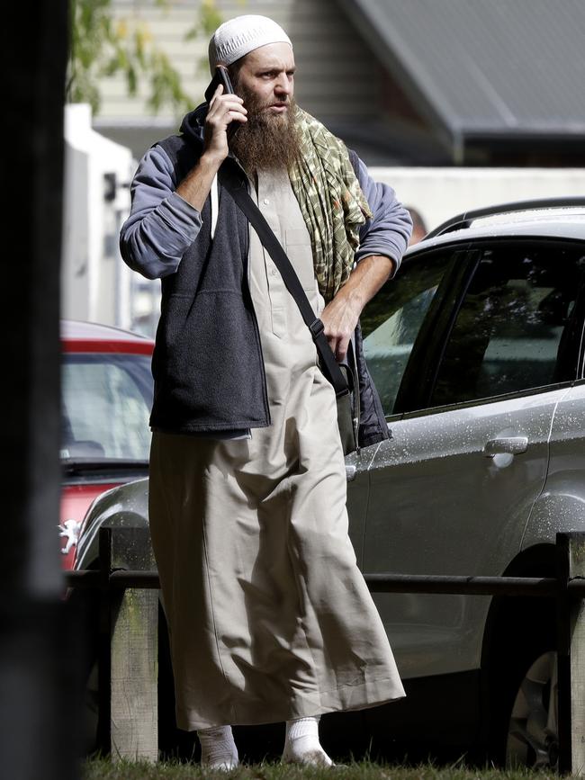 A man watches the scene at the Masjid Al Noor mosque as he talks on his phone. Picture: AP