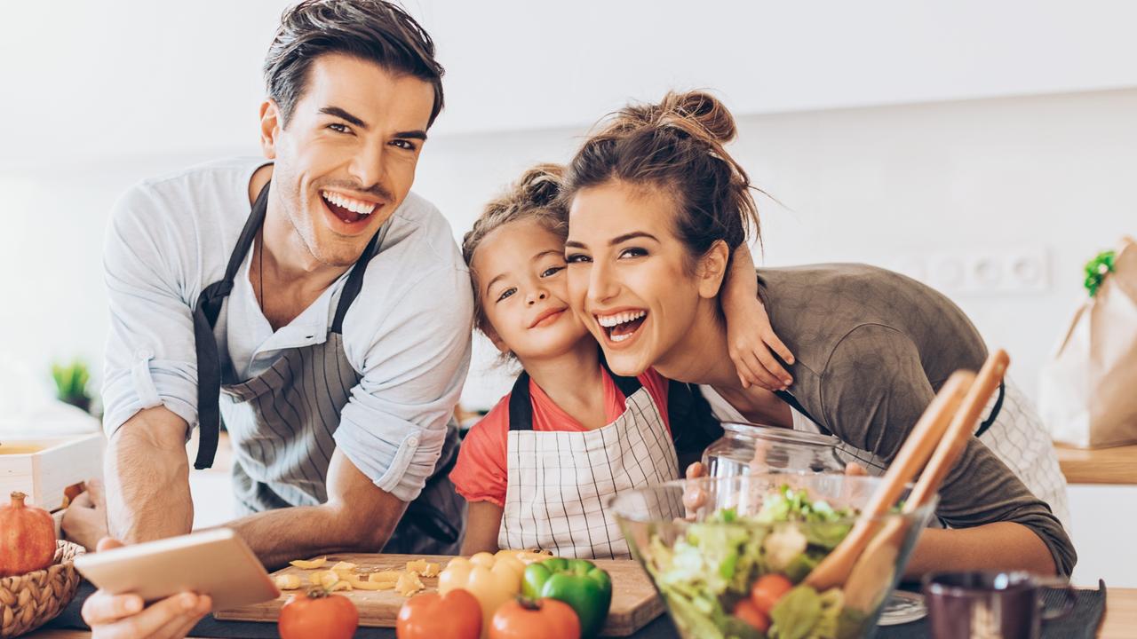 Beautiful young couple with small girl in the kitchen