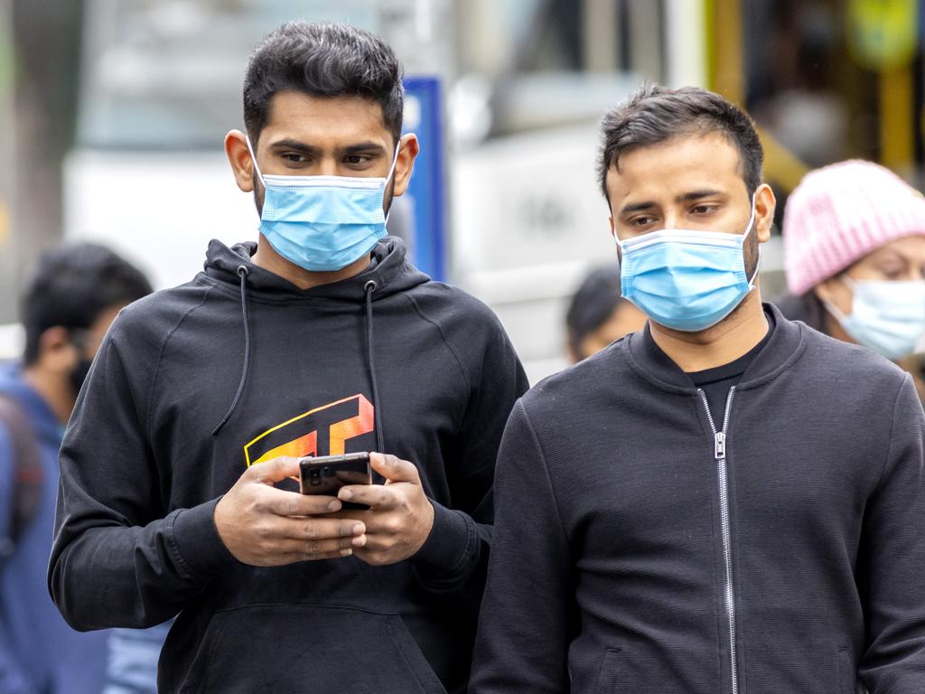 People get around Melbourne CBD wearing face masks.