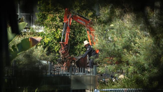 Investigators comb through the fire ruins by shovel and hand where two bodies where found overnight in Browns Plains. PICTURE: Brad Fleet