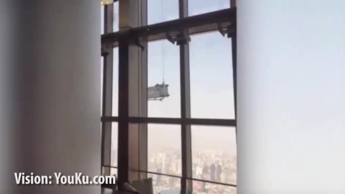 Skyscraper window cleaners battle heavy winds