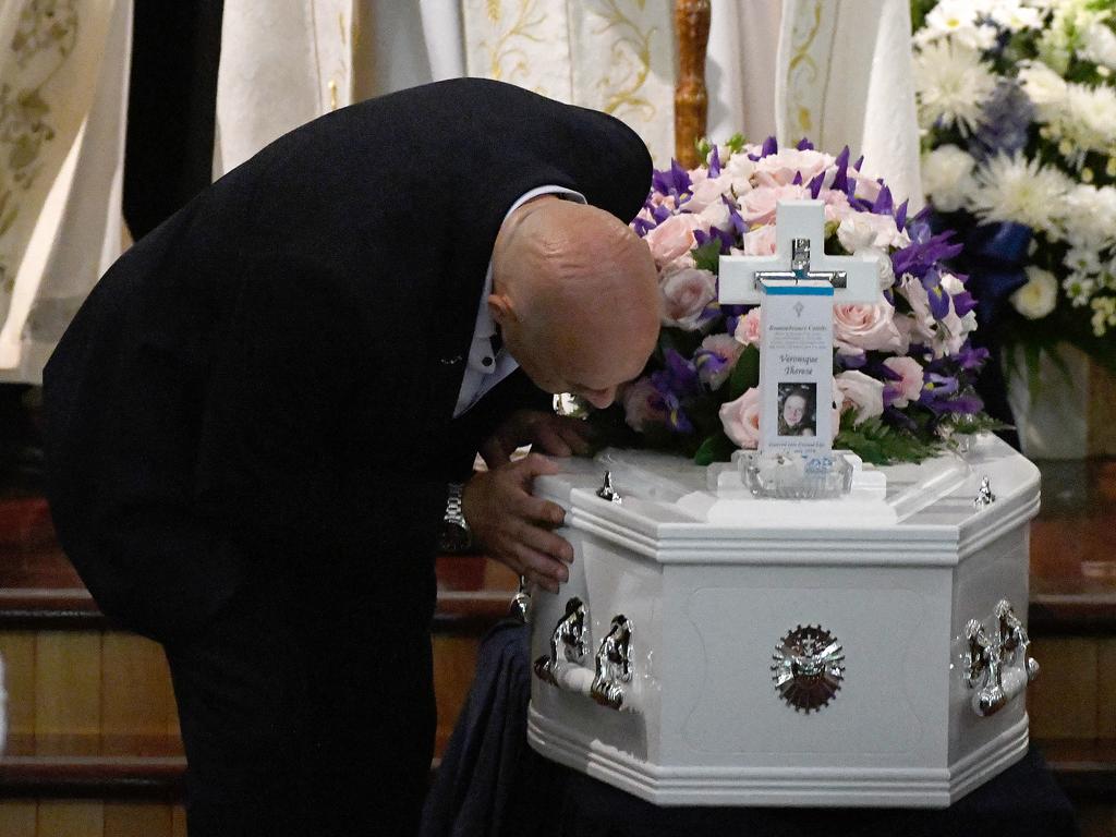 Bob Sakr kisses the coffin of his daughter Veronique Sakr, 11, during her funeral at the Santa Sabina College Chapel in Sydney, Tuesday, February 11, 2020.