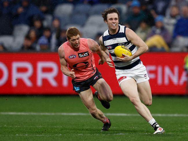 Max Holmes charges clear of Matt Rowell during Geelong’s victory.