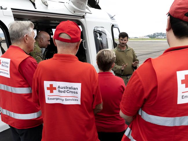 Volunteers from the Australian Red Cross listen to a passenger brief before embarking in an AW139 aircraft at 5th Aviation Regiment in support of the North Queensland floods in 2025.