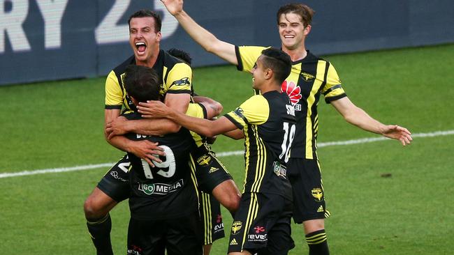 Wellington Phoenix’s Steven Taylor hugs teammate Tom Doyle while Sarpreet Singh and Alex Rufer also celebrate after the Roar’s own goal put the Phoenix ahead. Picture: Getty Images 