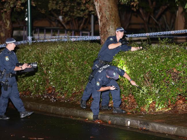 Police scour the scene the night Smart and his father were shot. Picture: Bill Hearne