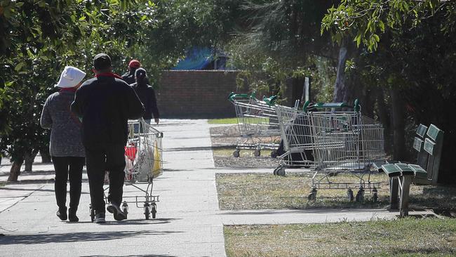 Shoppers with one of the many trolleys abandoned along Park Road, Cabramatta. Picture: Carmela Roche