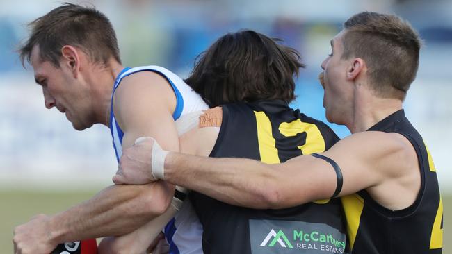 Anglesea’s Dylan Featon is claimed by Torquay’s Clay Page and Luke Mahony, with the latter receiving a yellow card in the final term. Picture: Mark Wilson