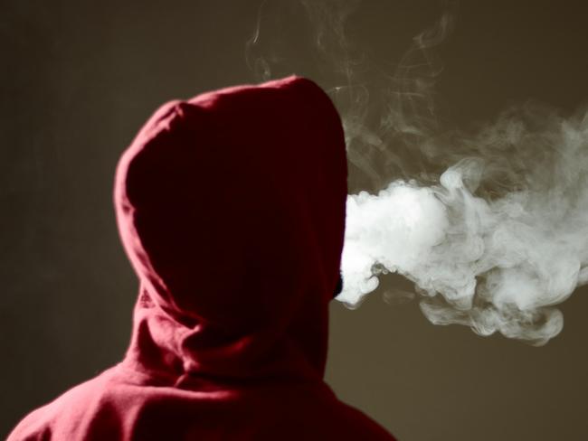 Young male in red hoodie vaping smoking, exhales thick vapor, isolated rear view Picture: iStock